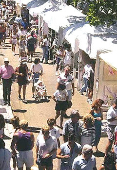 Gente paseando por mercadillo callejero